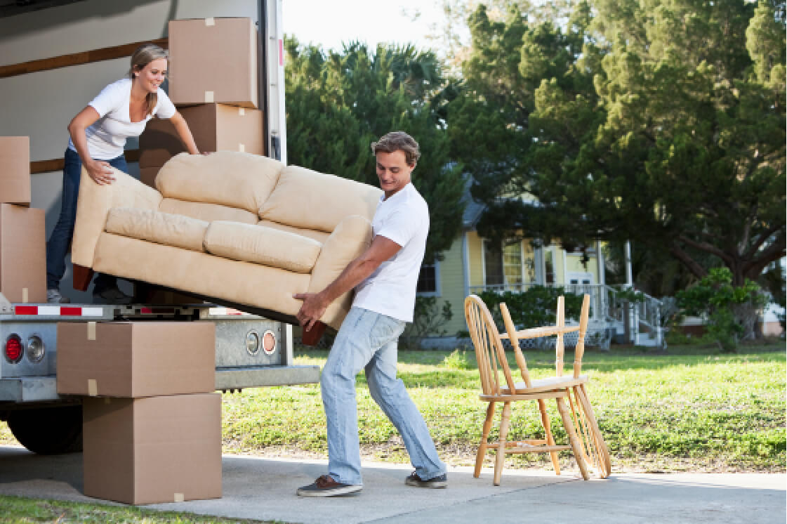Man and a woman moving a couch into a moving truck